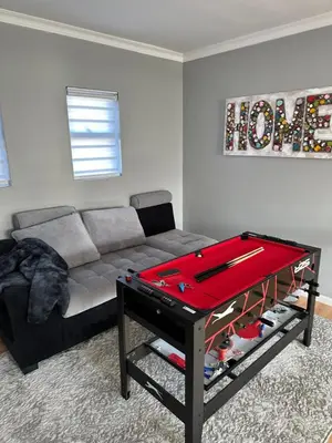 a living room with a couch and a ping pong table at YA Eagle Wings Self Catering Shared Single Room Lodge A in Cape Town