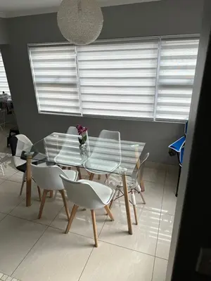 a dining room with a glass table and white chairs at YA Eagle Wings Self Catering Shared Single Room Lodge A in Cape Town