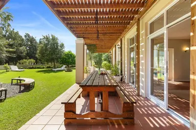 a wooden picnic table on the porch of a house at Farmhouse in Cape Town