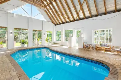 an indoor swimming pool with blue water in a house at Farmhouse in Cape Town