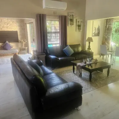 a living room with leather couches and a coffee table at Mimi's in Plattekloof