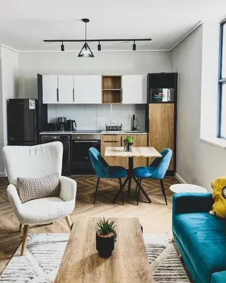 a living room with a table and chairs and a kitchen at Peace On Park by Dajosha booking in Cape Town