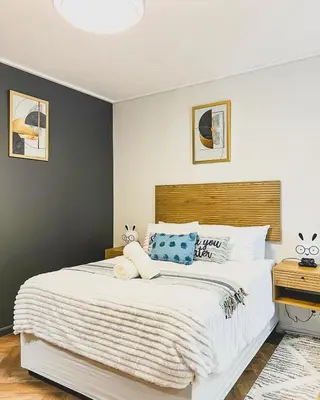 a bedroom with a large white bed with blue pillows at Love on Park by Dajosha bookings in Cape Town