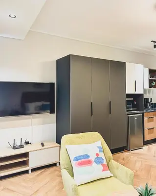 a living room with a chair and a tv at Love on Park by Dajosha bookings in Cape Town