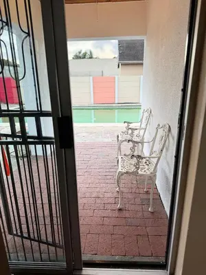 an open door to a patio with a chair outside at Miches House in Cape Town