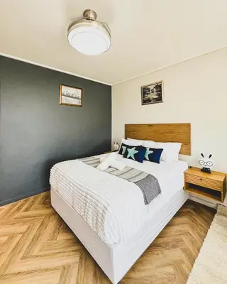 a bedroom with a large white bed and a blue wall at Joy On Park by Dajosha Bookings in Cape Town