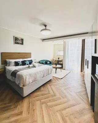 a bedroom with a bed and a wooden floor at Joy On Park by Dajosha Bookings in Cape Town