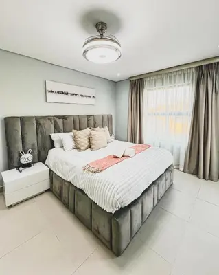 a bedroom with a large bed and a window at Hope Century Apartments in Cape Town