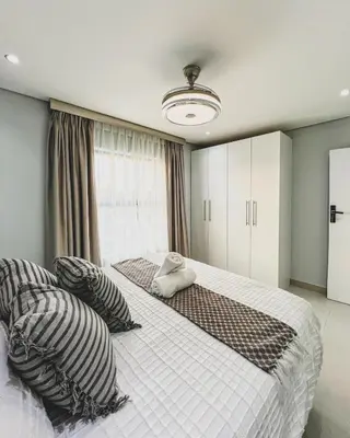 a bedroom with two beds and a window at Hope Century Apartments in Cape Town