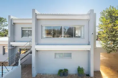 a white house with a window on the side of it at Self-Catering Winelands Views Apartment Stellenbosch in Stellenbosch