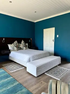 a bedroom with two beds and a blue wall at Blue Cottage, Elgin Grabouw in Grabouw