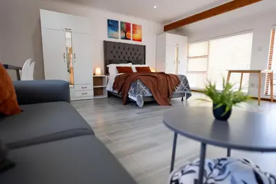 a bedroom with a bed and a table at Mystical Serenity in Durbanville