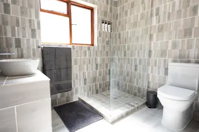 a bathroom with a toilet and a tub and a sink at Mystical Serenity in Durbanville