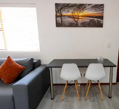 a living room with a couch and a table and two chairs at Mystical Serenity in Durbanville