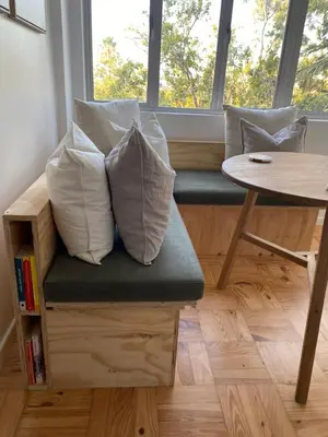 two pillows sitting on a bench in front of a window at The eden in Faure