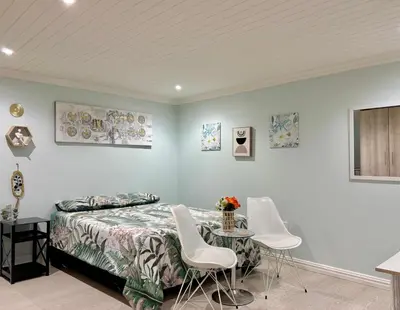 a bedroom with a bed and a table and chairs at Bachelor Flat A in Goodwood