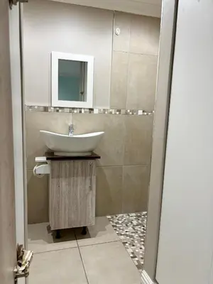a bathroom with a sink and a mirror at Bachelor Flat A in Goodwood