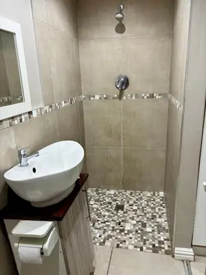 a bathroom with a sink and a shower at Bachelor Flat A in Goodwood