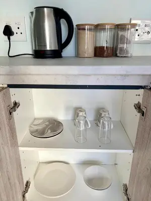 a shelf with two tea pots and a coffee maker at Bachelor Flat A in Goodwood