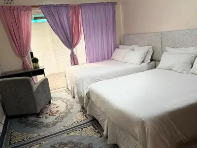 a bedroom with two beds and a window at Miches House in Cape Town