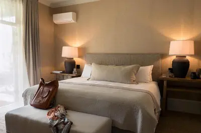 a hotel room with a bed with a purse on it at Pink Door Franschhoek by The Oyster Collection in Franschhoek