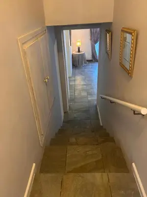 a hallway with a stairway with a door and a table at Bergstreet in Hermanus