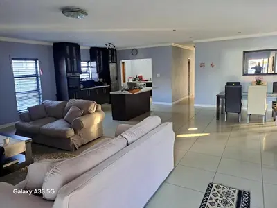 a living room with a couch and a kitchen at Spacious Home-Quiet area, Kuils river, Cape Town in Blackheath