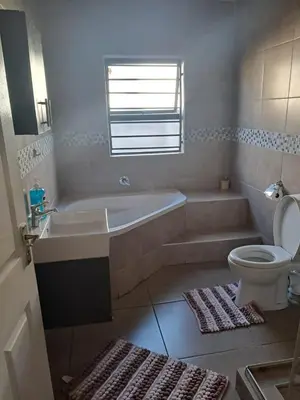 a bathroom with a tub and a toilet and a sink at Spacious Home-Quiet area, Kuils river, Cape Town in Blackheath