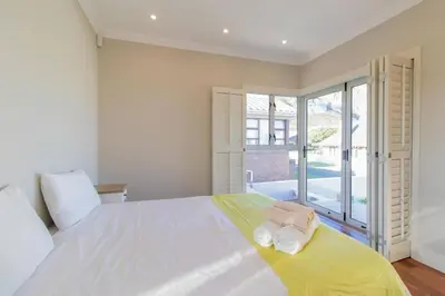 a bedroom with a large white bed with towels on it at Somer Sout in Voelklip, Hermanus in Hermanus