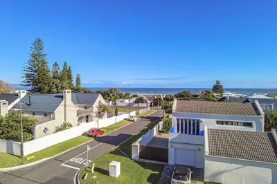 an aerial view of a neighbourhood with houses and the ocean at Somer Sout in Voelklip, Hermanus in Hermanus