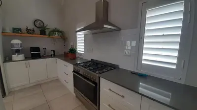 a kitchen with white cabinets and a stove top oven at Flow in Hermanus