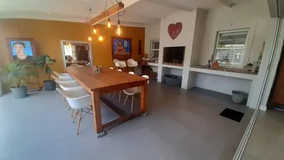 a dining room with a wooden table and white chairs at Flow in Hermanus