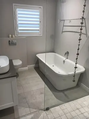 a white bathroom with a tub and a toilet at Flow in Hermanus