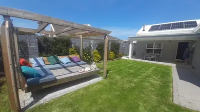 a garden with a couch under a pergola at Flow in Hermanus