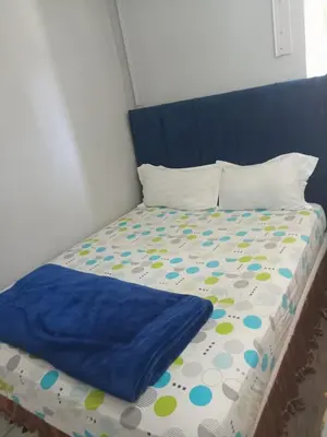 a bed with a blue headboard and polka dot sheets at BDC Paarl Accommodation and Guest House in Paarl