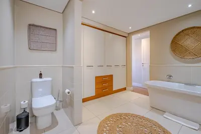a bathroom with a toilet and a tub and a sink at Hermanus Marine Square spacious 1 bedroom- central & close to sea in Hermanus