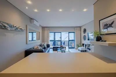 a living room with a large table in the middle at Hermanus Marine Square spacious 1 bedroom- central & close to sea in Hermanus