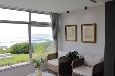 a living room with two chairs and a large window at Bayview 107 in Hermanus