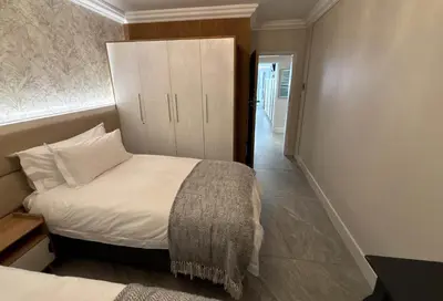 a small bedroom with a bed and a cabinet at Bayview 107 in Hermanus