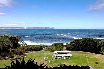a picnic table on a hill overlooking the ocean at Bayview 107 in Hermanus