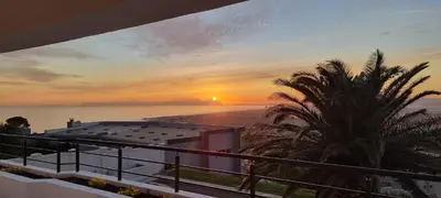 a view of a sunset from the balcony of a house at Coral Vistas Self Catering Apartments in Gordonʼs Bay