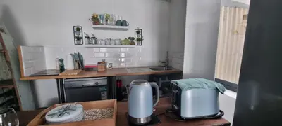 a small kitchen with a table and a counter top at Coral Vistas Self Catering Apartments in Gordonʼs Bay