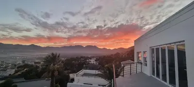 a view of a sunset from the balcony of a house at Coral Vistas Self Catering Apartments in Gordonʼs Bay