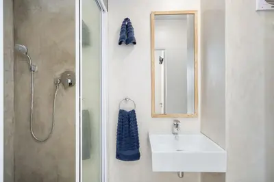 a bathroom with a sink and a mirror and a shower at 14 Cap dAzur by Host Agents in Cape Town