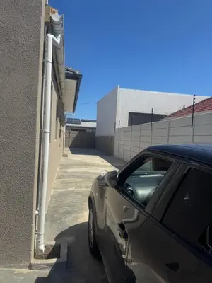 a car parked next to a building with pipes on it at Comfort Guest House in Tiervlei