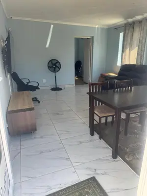 a living room with a table and a couch at Comfort Guest House in Tiervlei