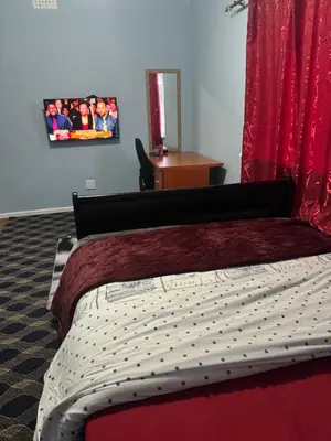 a bedroom with a bed and a picture on the wall at Comfort Guest House in Tiervlei