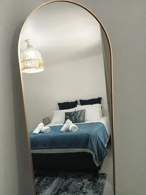 a bedroom with a bed and a large mirror at Pinelands Apartment in Cape Town