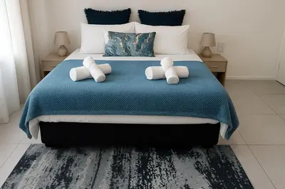 a bedroom with a bed with two pillows on it at Pinelands Apartment in Cape Town