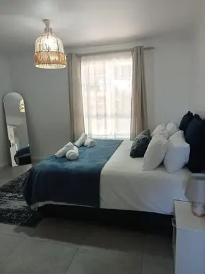a bedroom with a large bed and a window at Pinelands Apartment in Cape Town